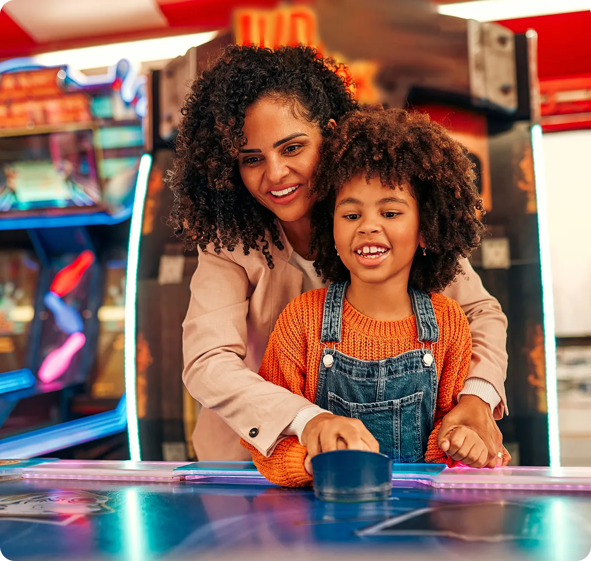 Mother and child playing air hockey together.
