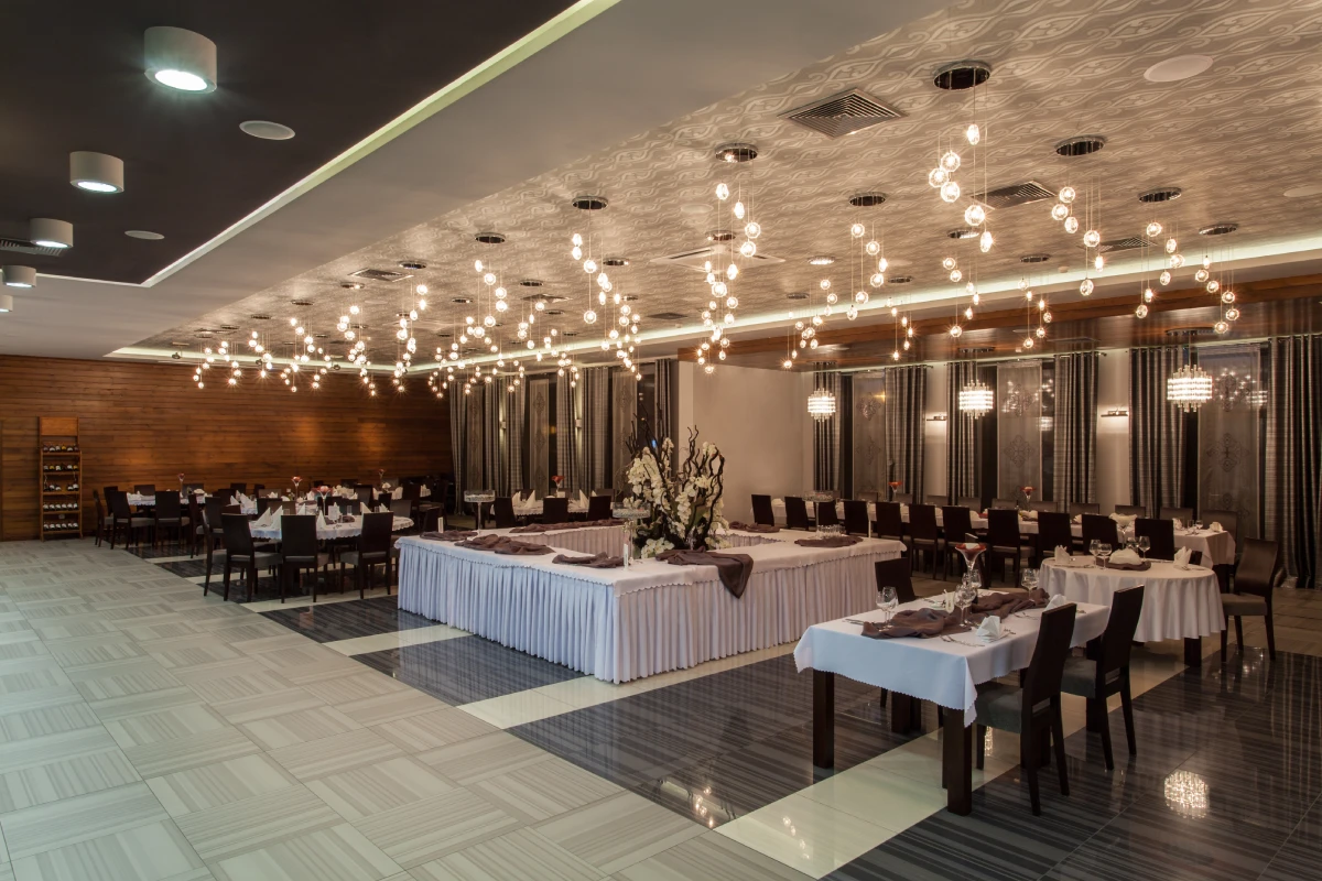 Elegant restaurant with modern lighting and tables.